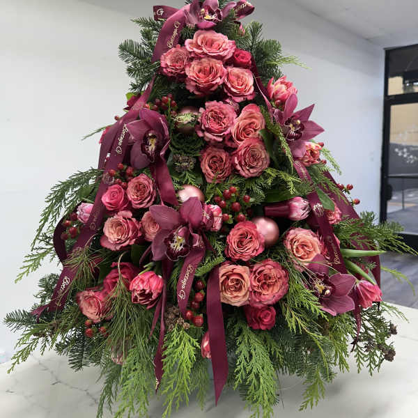 Pink roses and orchids arranged in a tree shape with burgundy ribbons