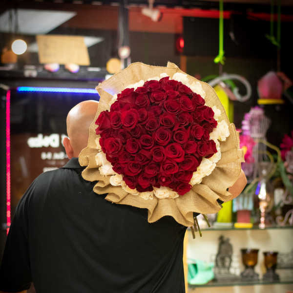 Large bouquet of red and white roses wrapped in burlap