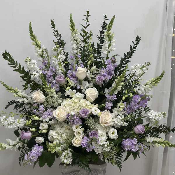Large white and lavender floral arrangement in a vase