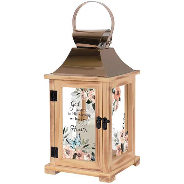Wooden memorial lantern with floral panels and a candle inside