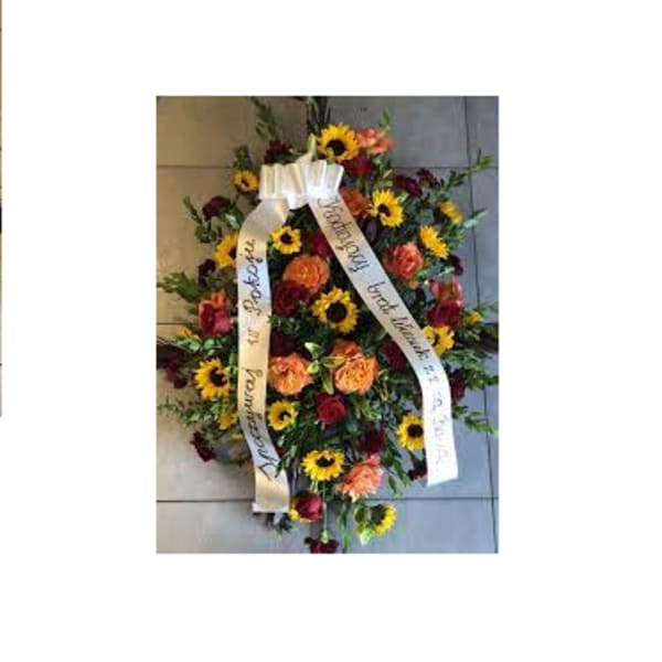 Standing floral spray with sunflowers and roses, finished with white ribbons