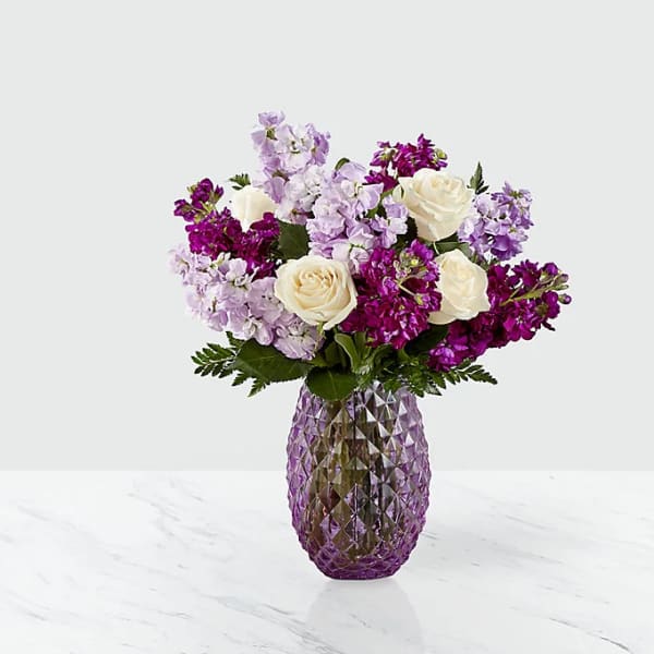Purple and white bouquet in a faceted purple vase
