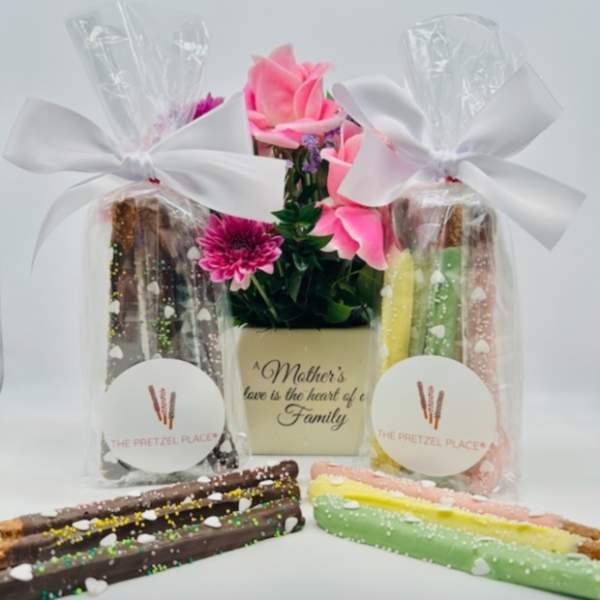 Gift set with pink flowers and decorated pretzel rods in clear bags