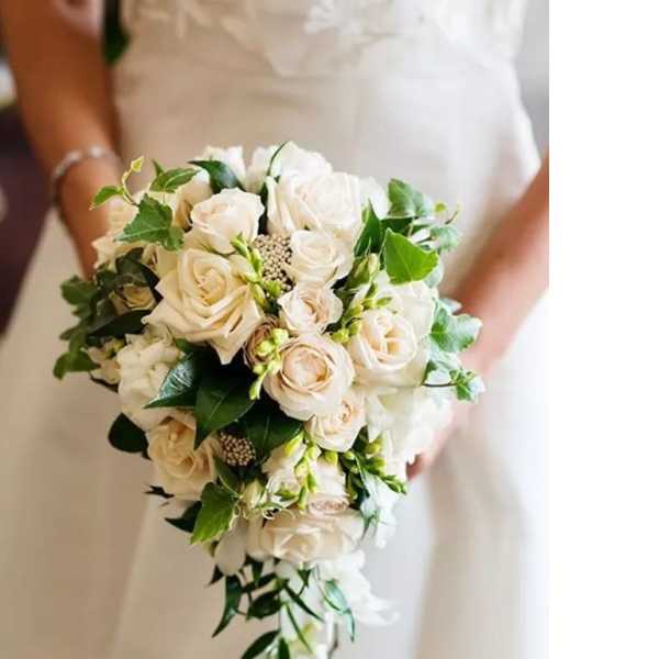 Bride holding a cascading bouquet of white roses and greenery
