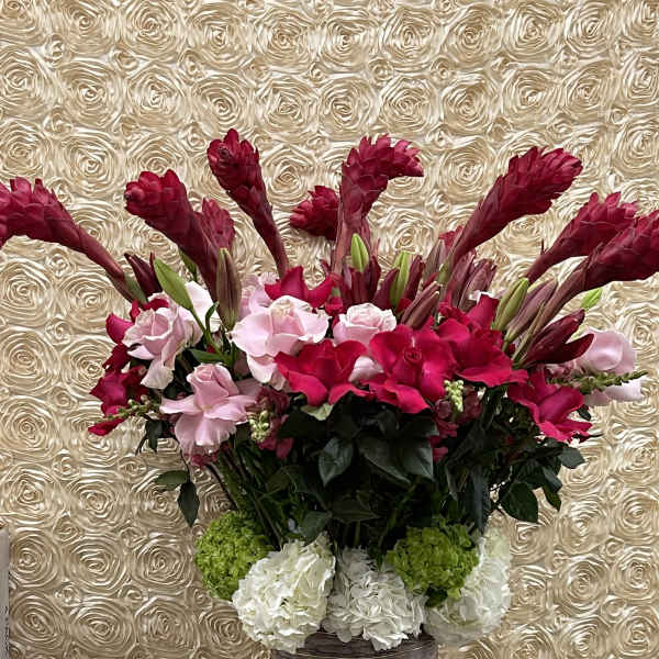 Tall bouquet of pink and white flowers in a wrapped vase