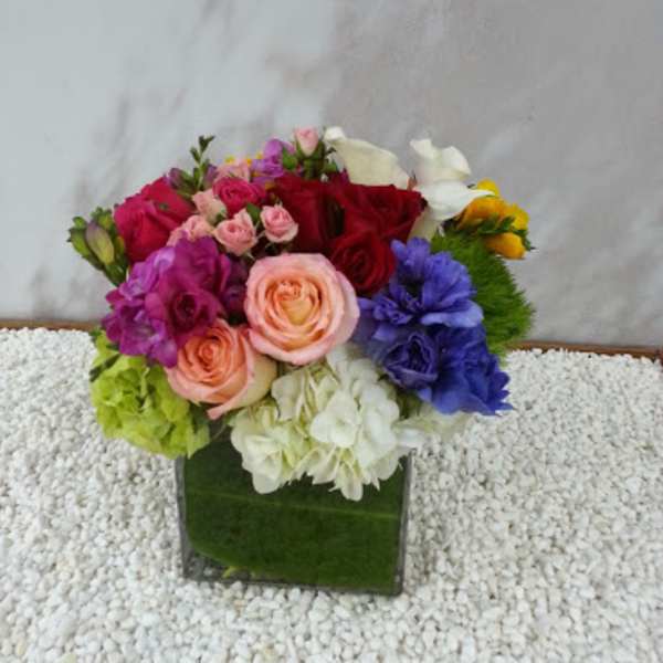 Colorful mixed bouquet in a square green vase