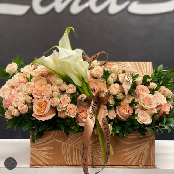 Peach roses and white calla lilies in a decorative box