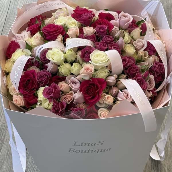 Bouquet of pink, cream, and red roses in a gift box