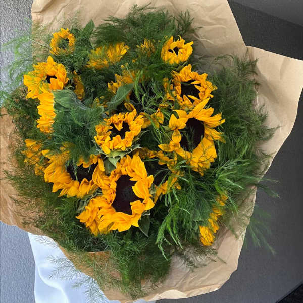 Bouquet of yellow sunflowers wrapped in brown paper