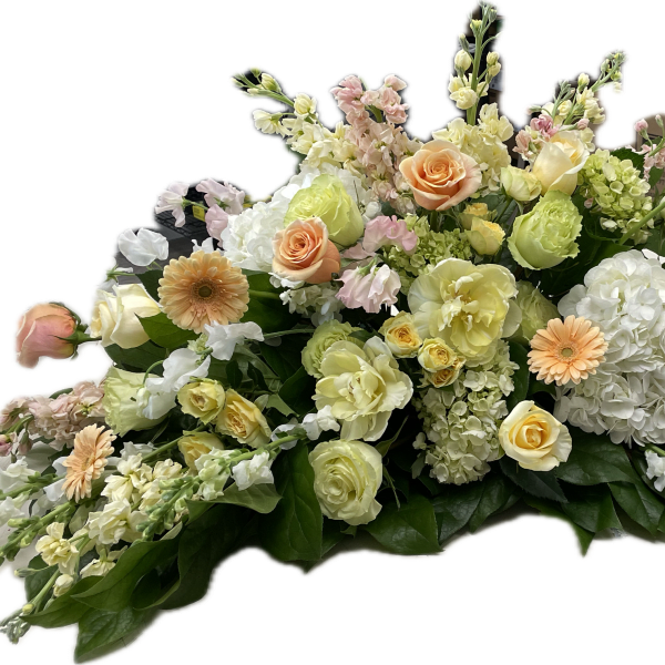 Low floral arrangement with peach, cream, and white blooms