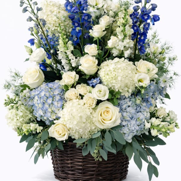 Blue and white floral arrangement in a wicker basket