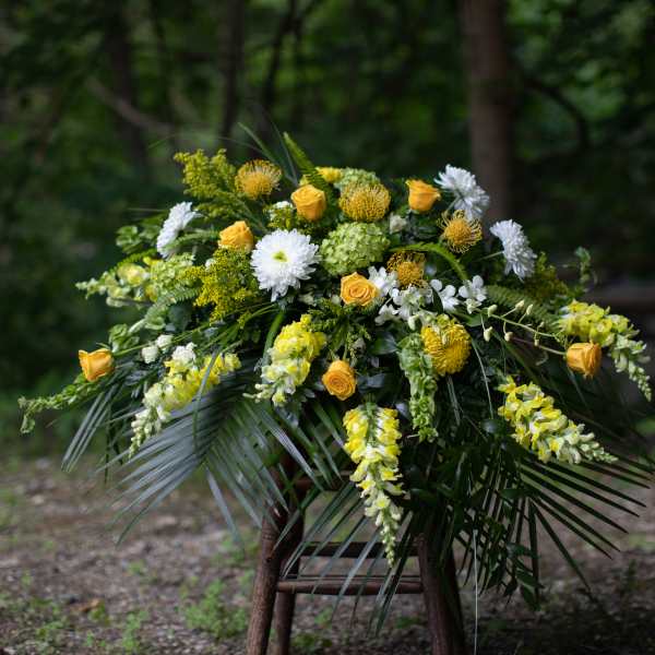 Yellow and white floral arrangement with cascading blooms