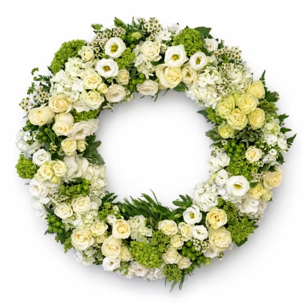Circular floral wreath of white and cream roses with green accents