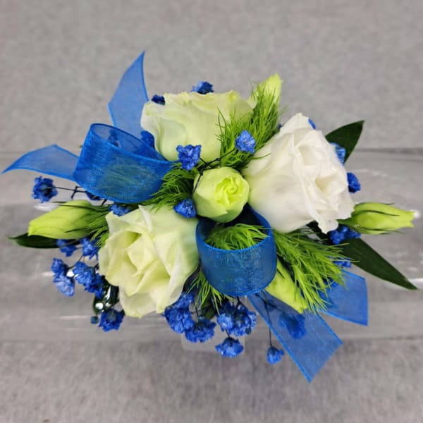 White roses with blue ribbon and small blue filler flowers