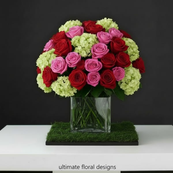 Bouquet of red and pink roses in a clear glass vase