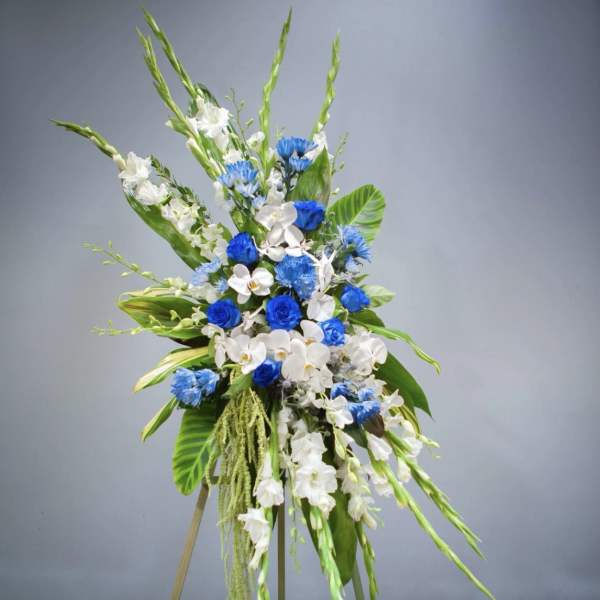 Tall blue and white floral standing spray with orchids and gladiolus