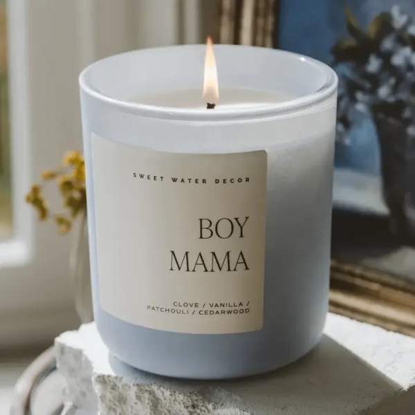 Lit white candle in a glass jar labeled Boy Mama