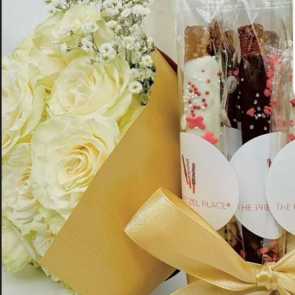 White rose bouquet beside wrapped chocolate bars in clear plastic