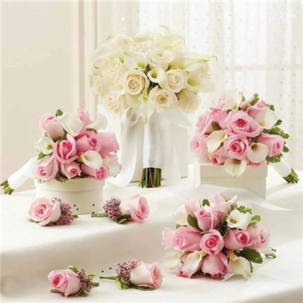 Pink and white rose bouquets with calla lilies on a white table
