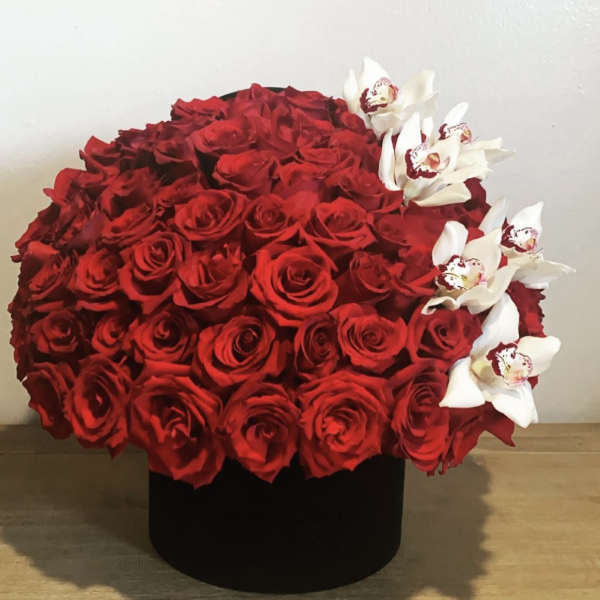 Large red rose arrangement with white orchids in a black box