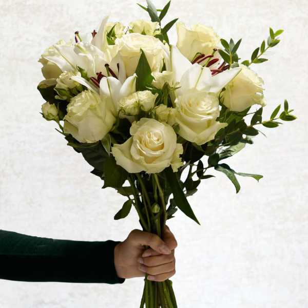 Handheld bouquet of white roses and lilies