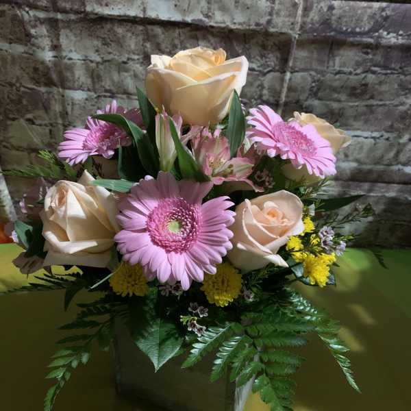 Bouquet of peach roses and pink gerbera daisies in a vase