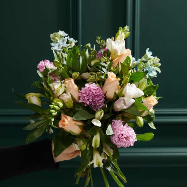 Hand-tied bouquet of peach and white flowers with pink blooms