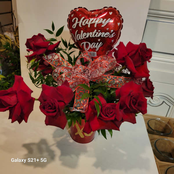 Red roses in a vase with a heart-shaped Valentine's Day balloon