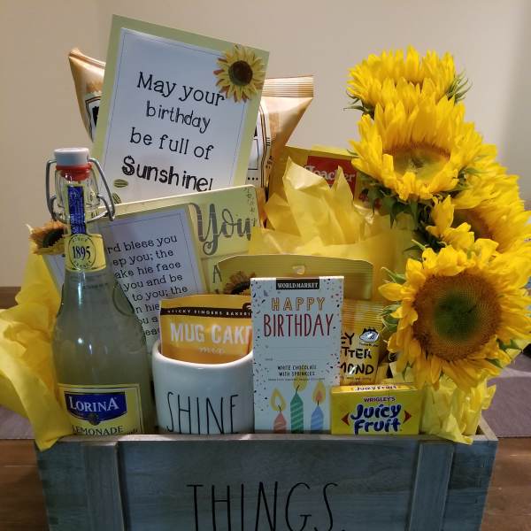 Gift basket with sunflowers, cards, candy, and a bottle of lemonade