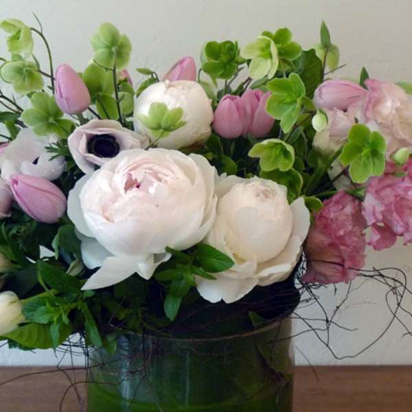 Pink and white floral arrangement in a green vase