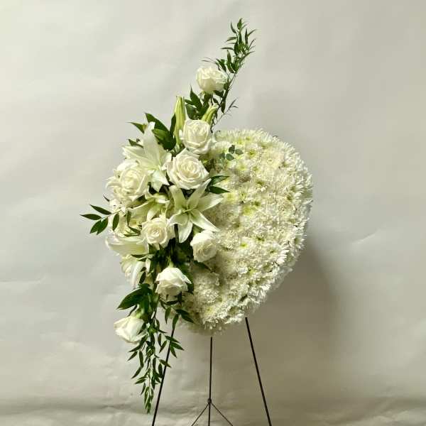 White floral standing spray with roses and lilies on an easel