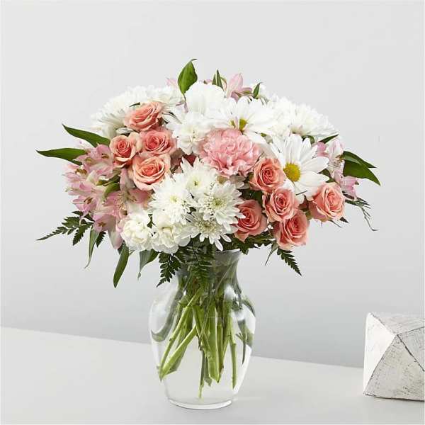 Pink roses and white daisies in a clear glass vase