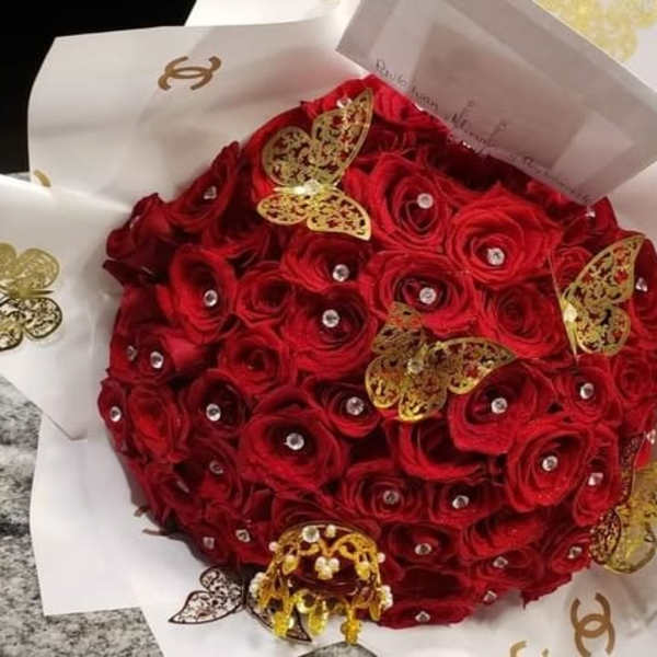 Round bouquet of red roses with gold butterfly accents and rhinestones
