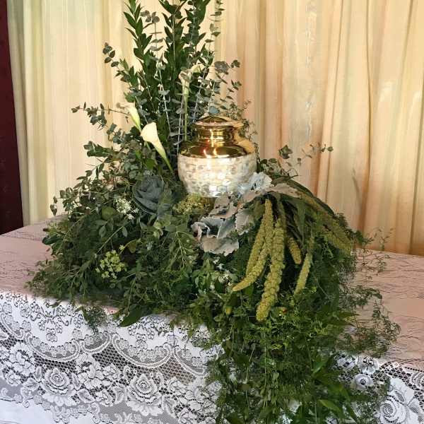 Large greenery arrangement with white calla lilies and a gold urn centerpiece