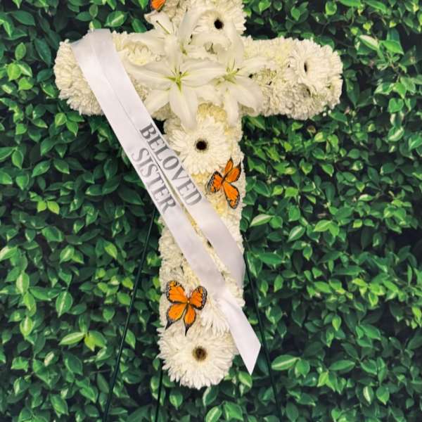 White floral cross with a memorial ribbon and orange butterflies