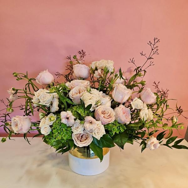 Blush and white rose arrangement in a white vase