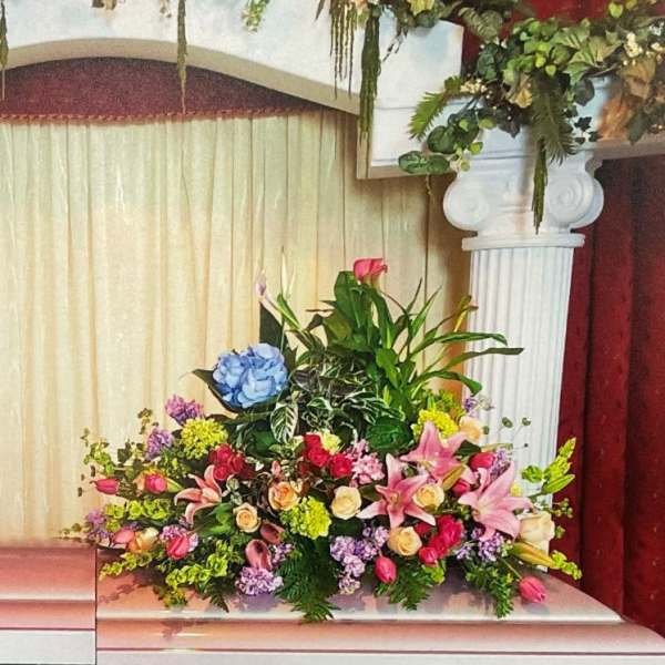 Floral arrangements with pink, purple, and white flowers on a stage with columns