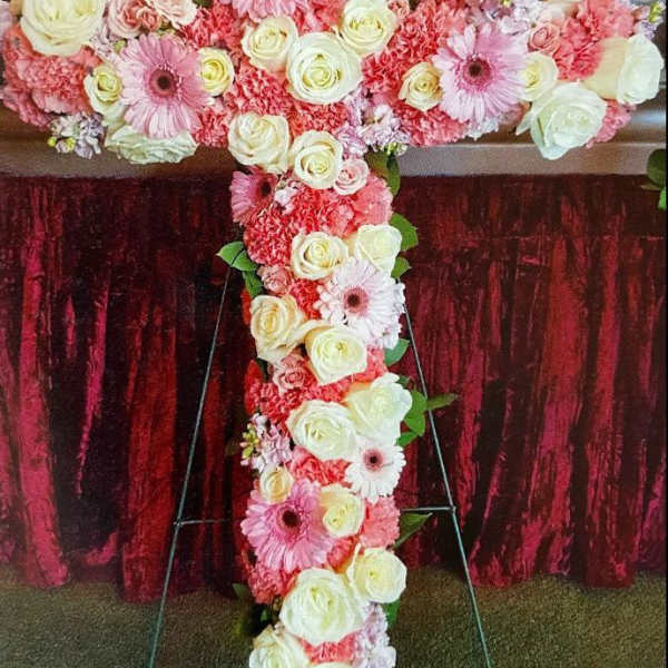 Large floral cross covered in pink and white flowers
