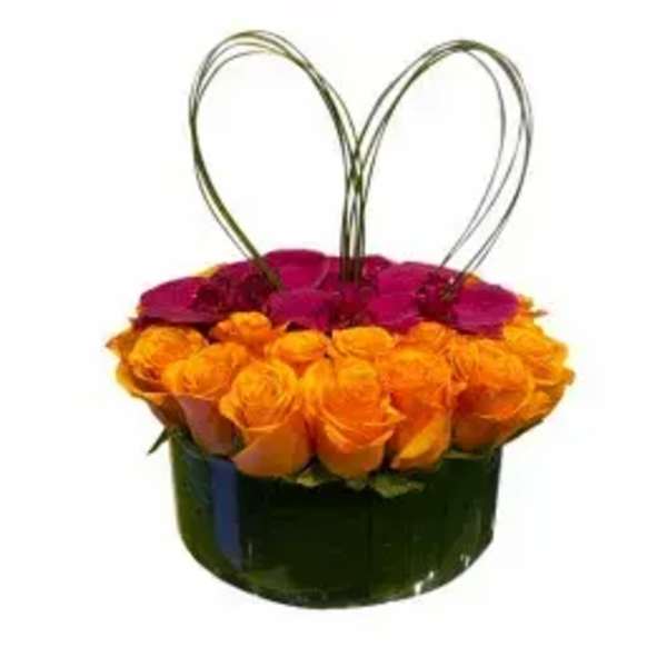 Round box of orange and magenta roses with wire heart handles