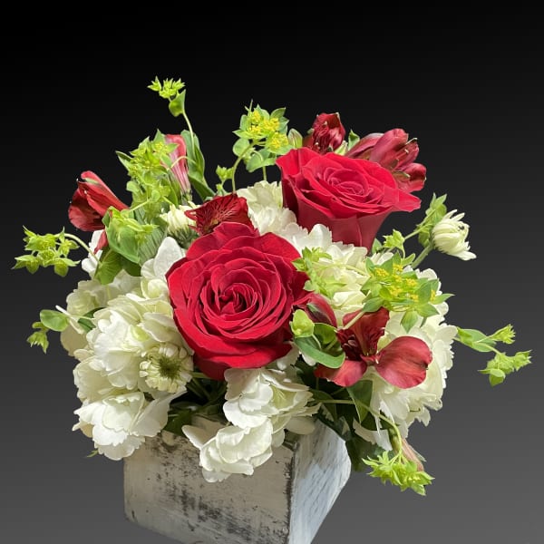 Red roses and white flowers in a rustic square container
