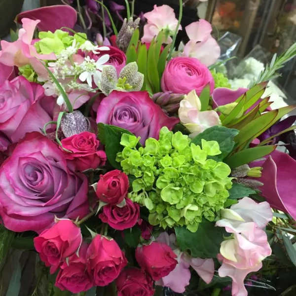 Bouquet of pink and purple roses with green hydrangea and pale sweet peas