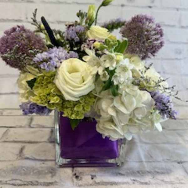Bouquet of white and lavender flowers in a purple vase