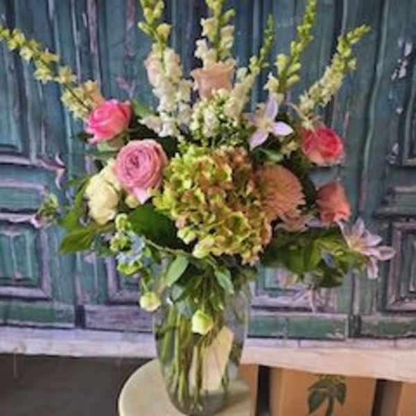 Tall mixed flower arrangement in a clear glass vase