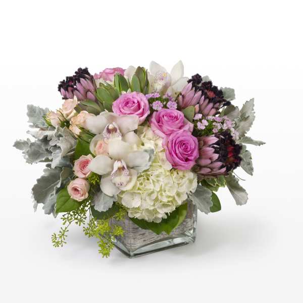 Pink roses and white orchids in a square glass vase