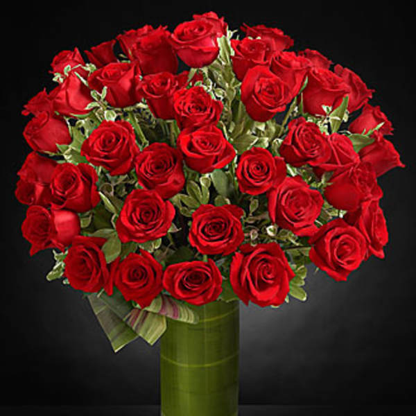 Bouquet of red roses in a tall glass vase