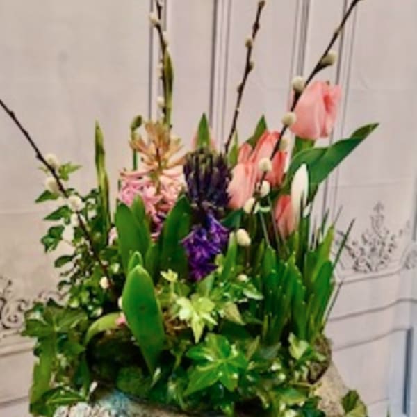Tall floral arrangement with pink tulips, purple blooms, and pussy willow branches