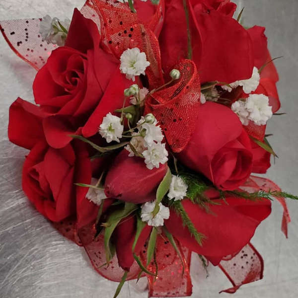 Bouquet of red roses with small white filler flowers and red mesh ribbon