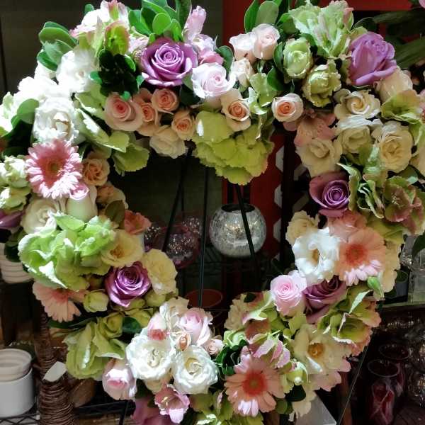 Heart-shaped floral wreath with pastel roses and gerbera daisies