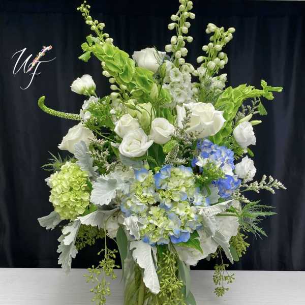 White roses and blue hydrangeas in a glass vase