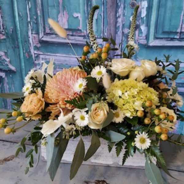 Mixed bouquet of cream, peach, and yellow flowers with berries